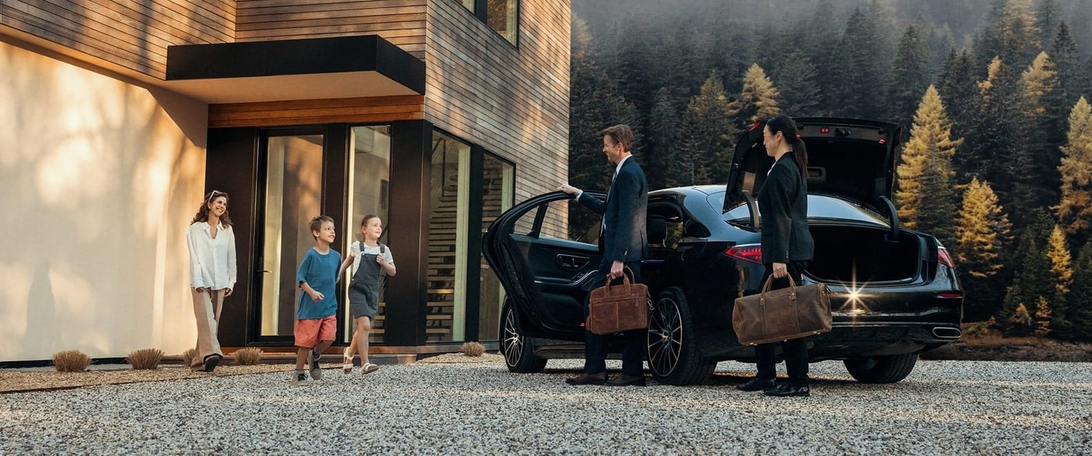 Adults and children with luggage beside a black vehicle outside a lodge