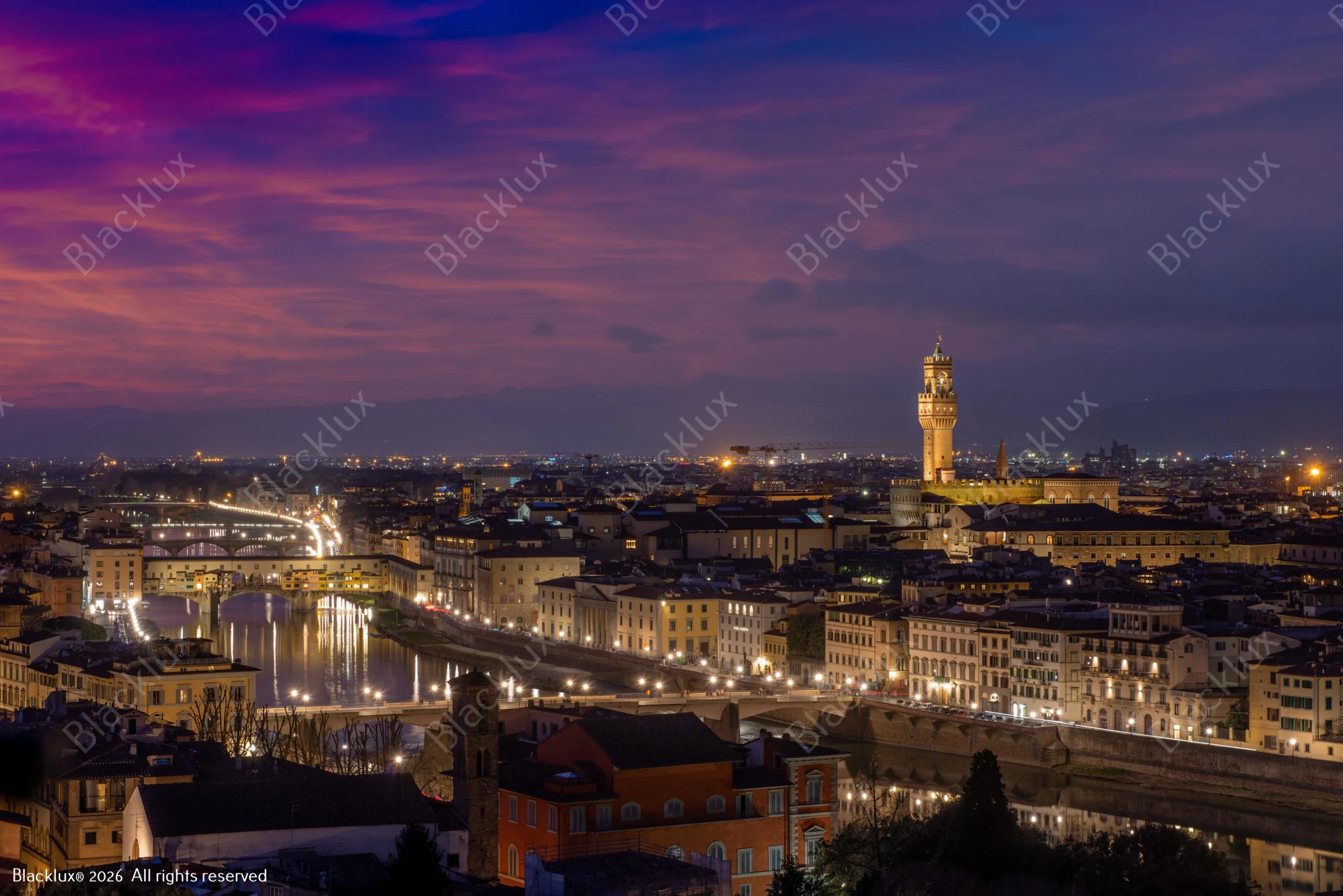 Evening view of Florence along the Arno with Ponte Vecchio and the tower of Palazzo Vecchio