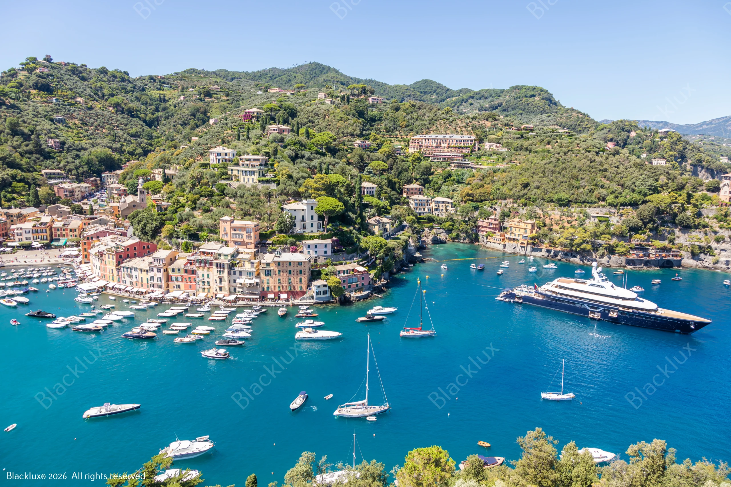 Elevated view over Portofino harbour, boats and surrounding green hills