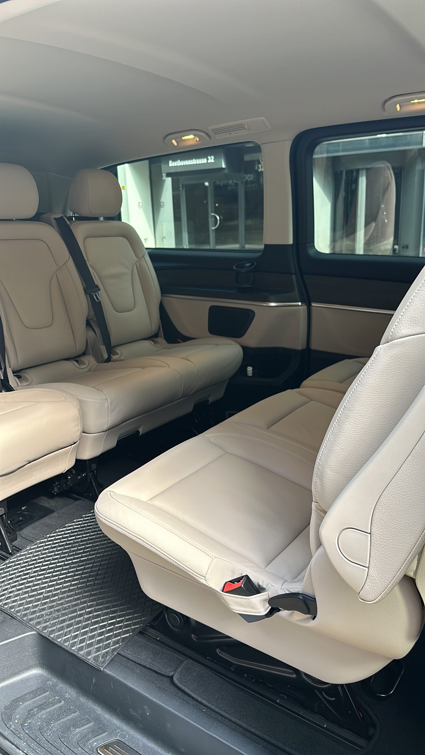 Cream-coloured passenger seats viewed through the open side door of a van