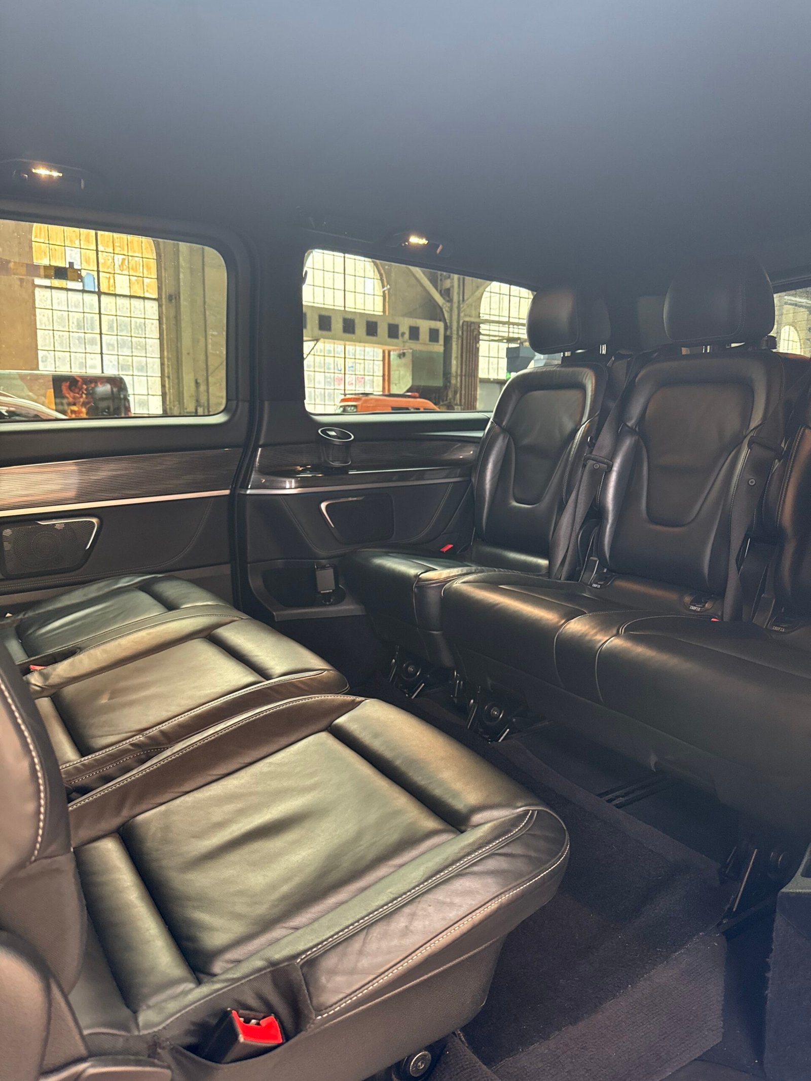 Rows of dark passenger seats inside a van in daylight