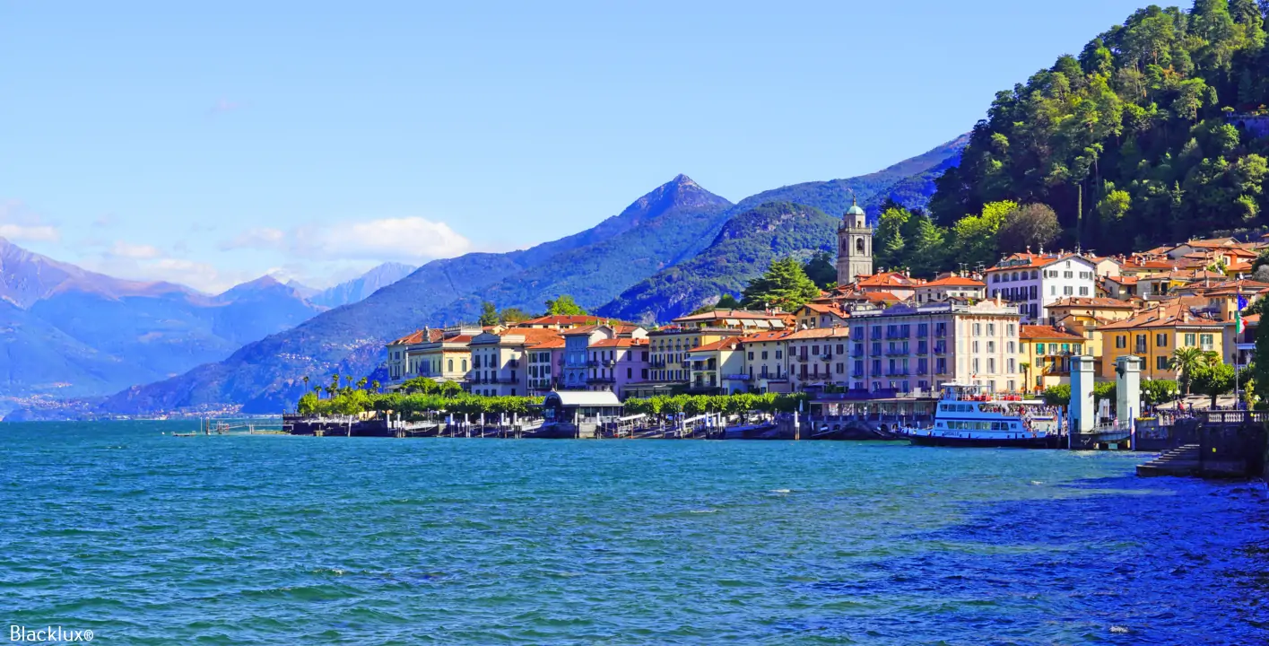 Bellagio waterfront seen from Lake Como, with pastel buildings and green mountain slopes