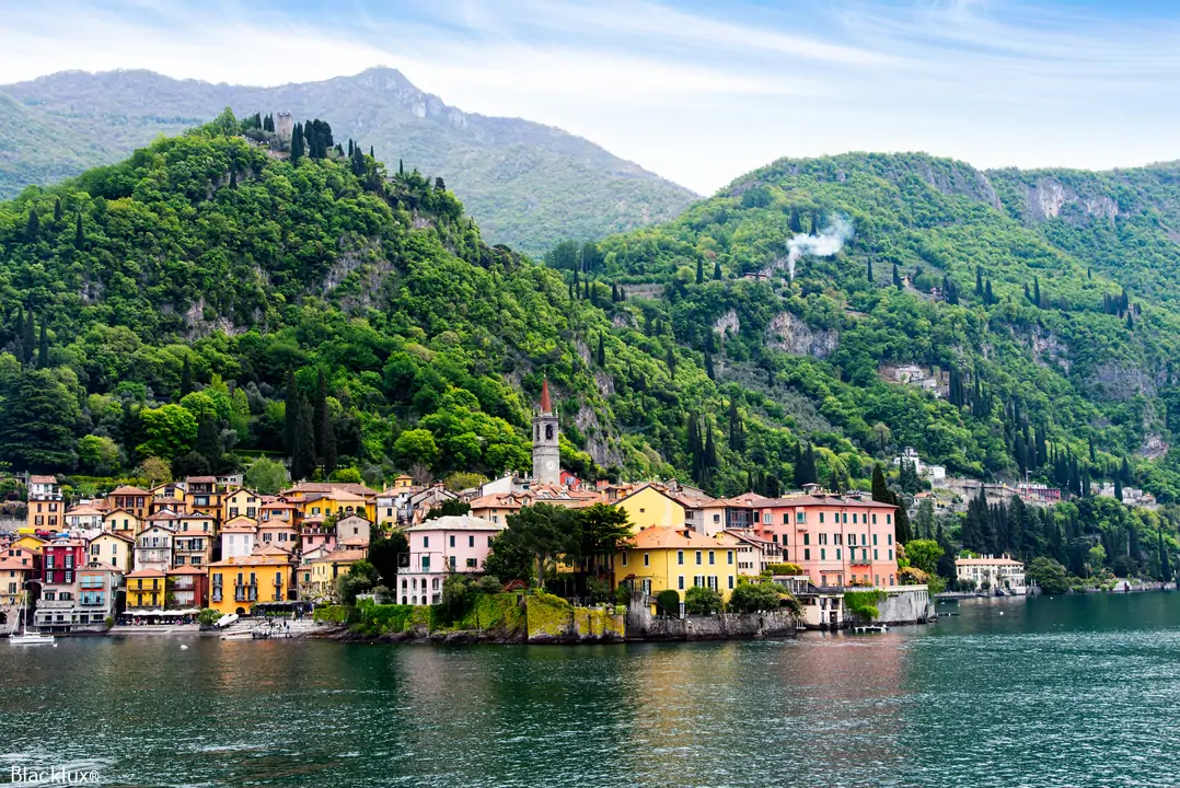Varenna waterfront buildings beneath a wooded hillside