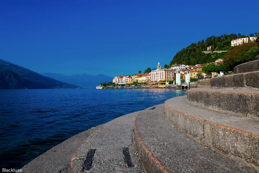 Stone waterfront steps beside a lake and distant shoreline buildings