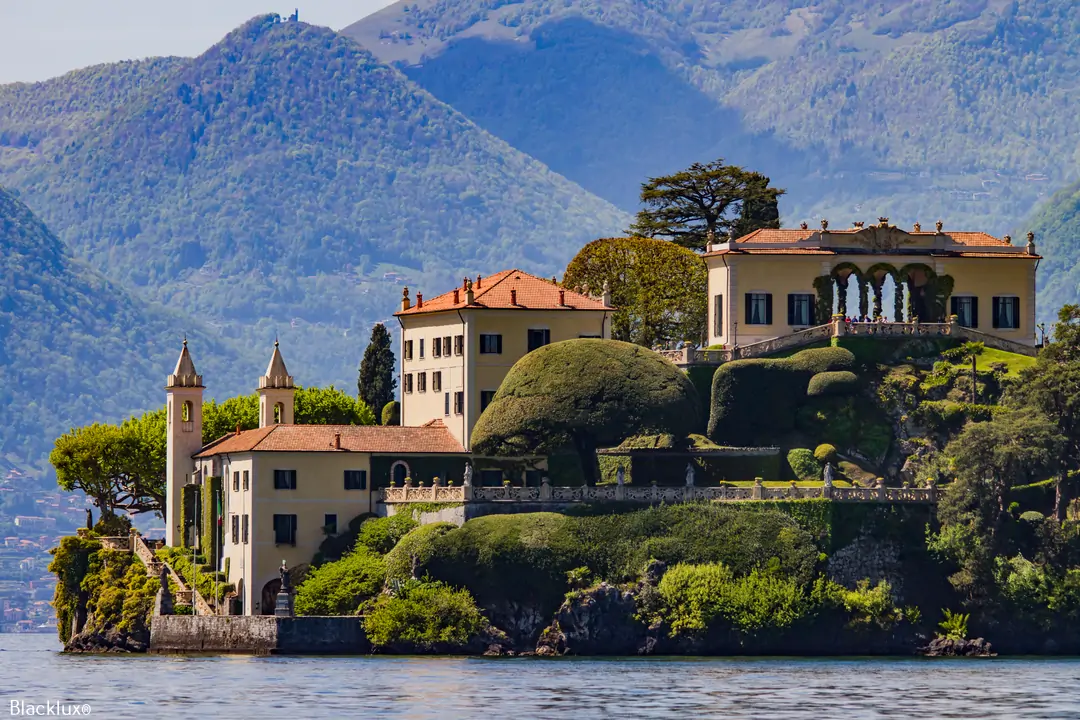 Villa del Balbianello seen from the water, with its lakeside buildings, loggia and shaped garden trees