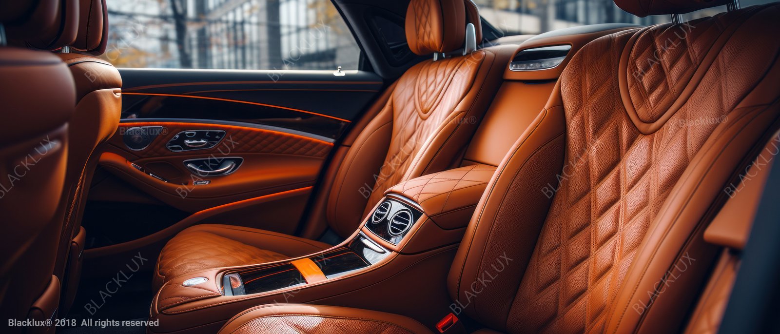 Oblique view of cognac leather rear seats and a central console in a luxury car