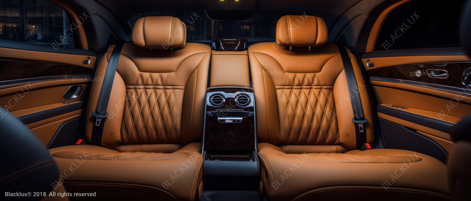Two tan quilted rear seats viewed straight on with a dark central console
