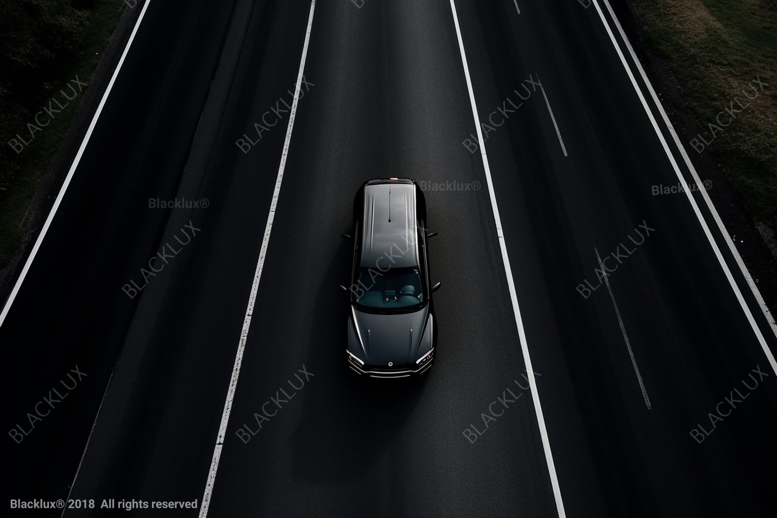 Overhead view of a dark vehicle between white road markings