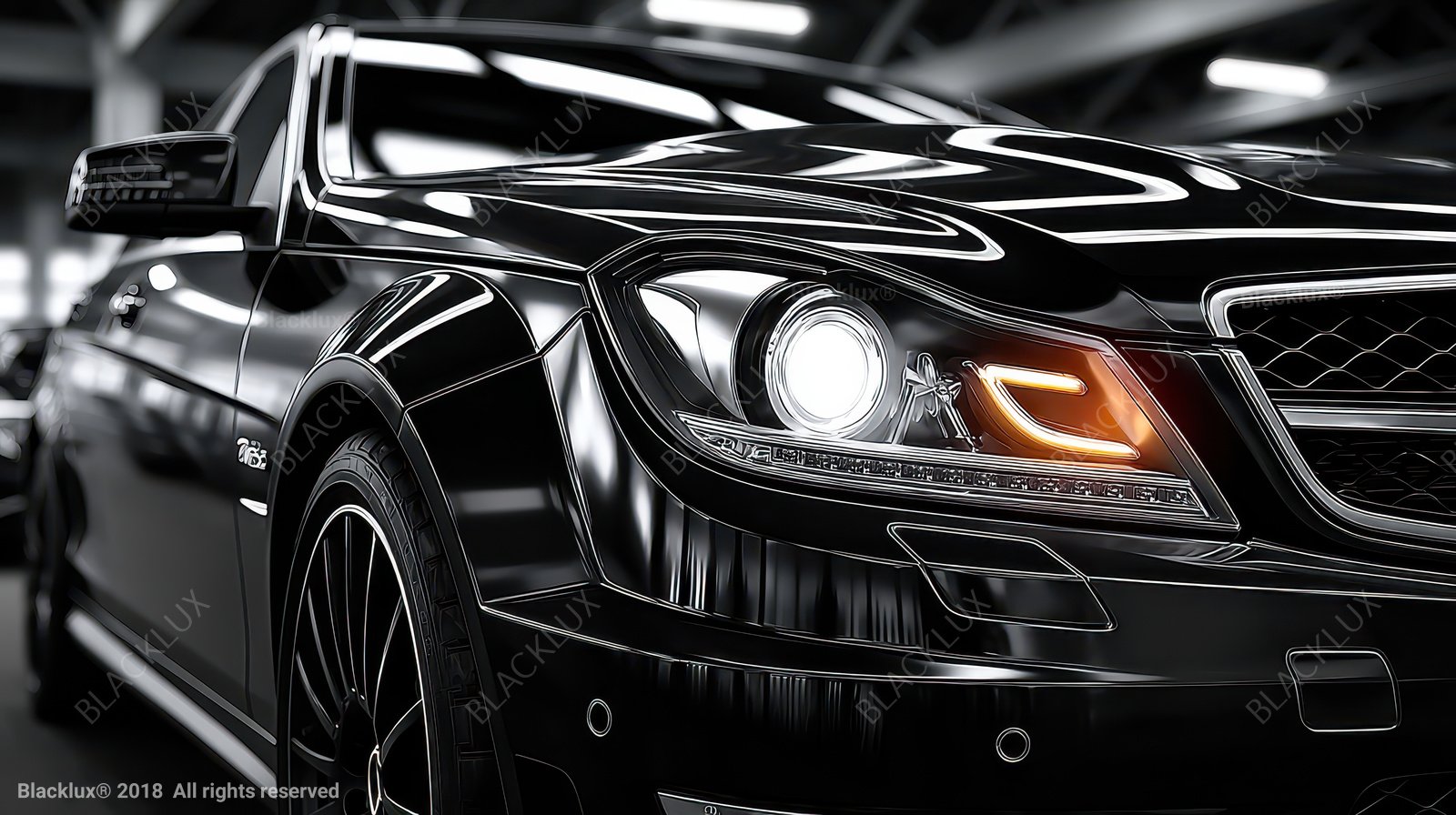 Close view of a black car with bright overhead reflections and an amber lamp detail