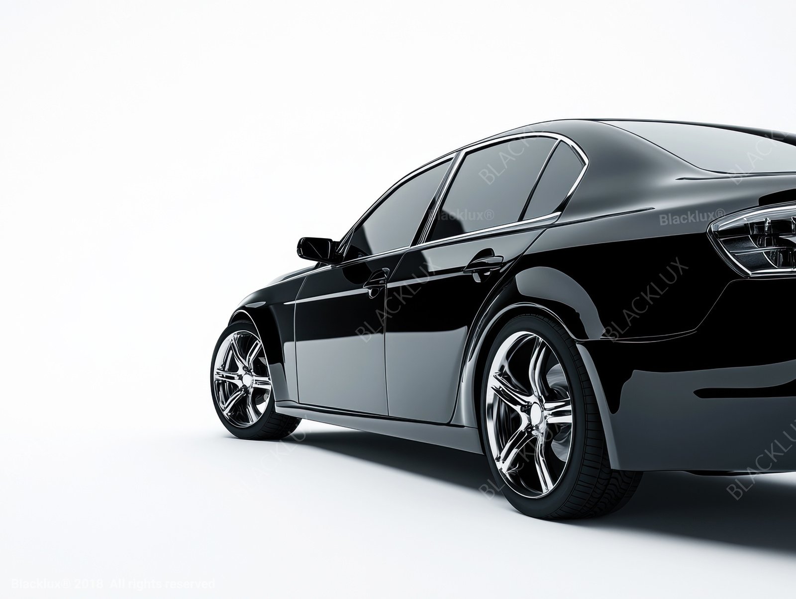 Three-quarter view of a black sedan against a pale studio background